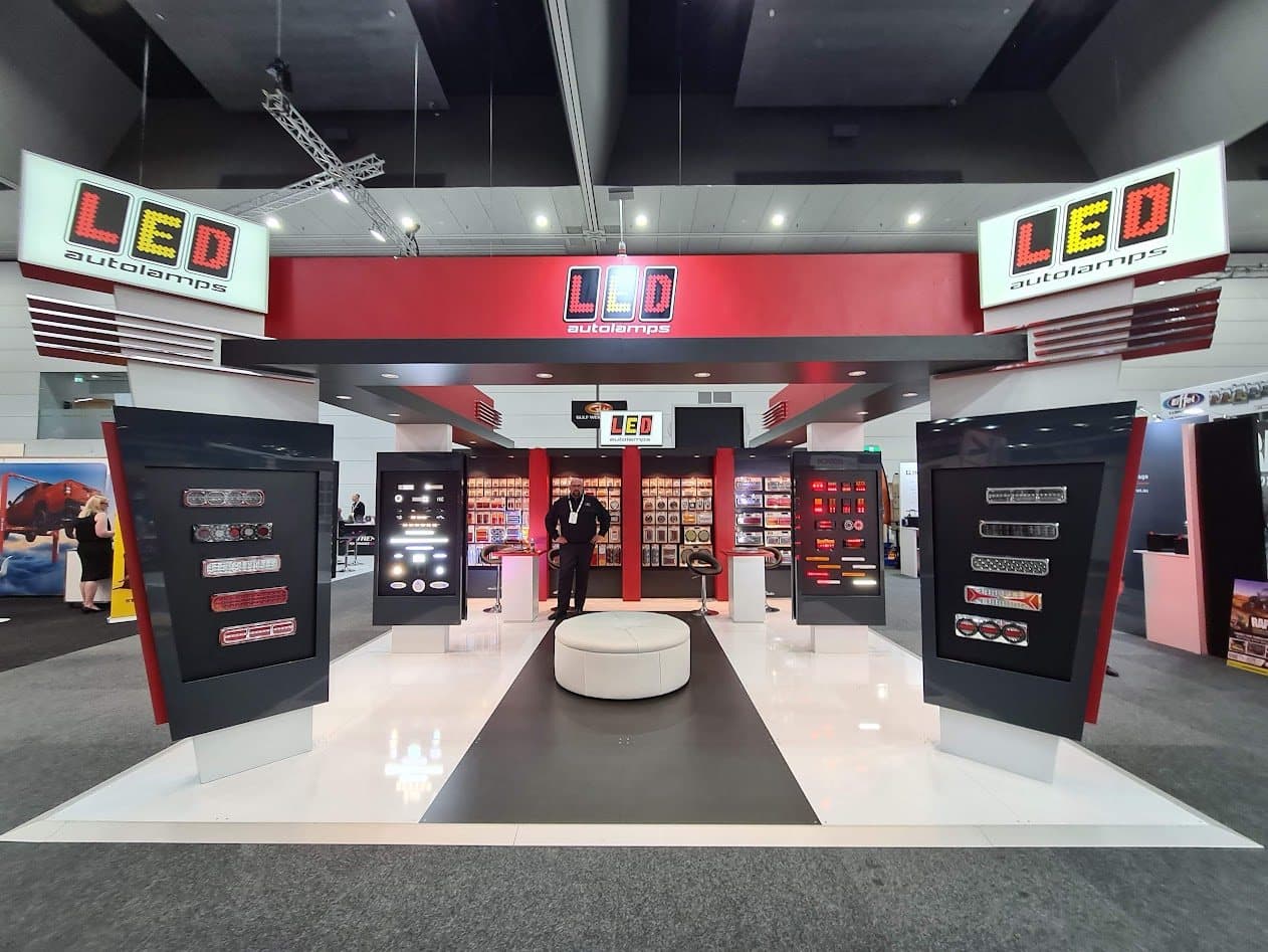 LED Autolamps trade show stand, with backlit product displays either side of a central walkway